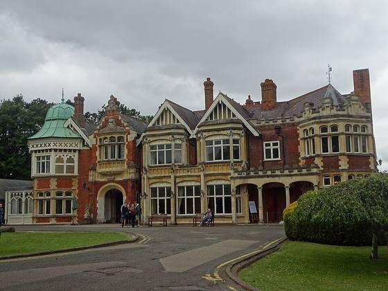 The red-brick and stone Victorian mansion at Bletchley Park with gables, bay windows and a green copper dome